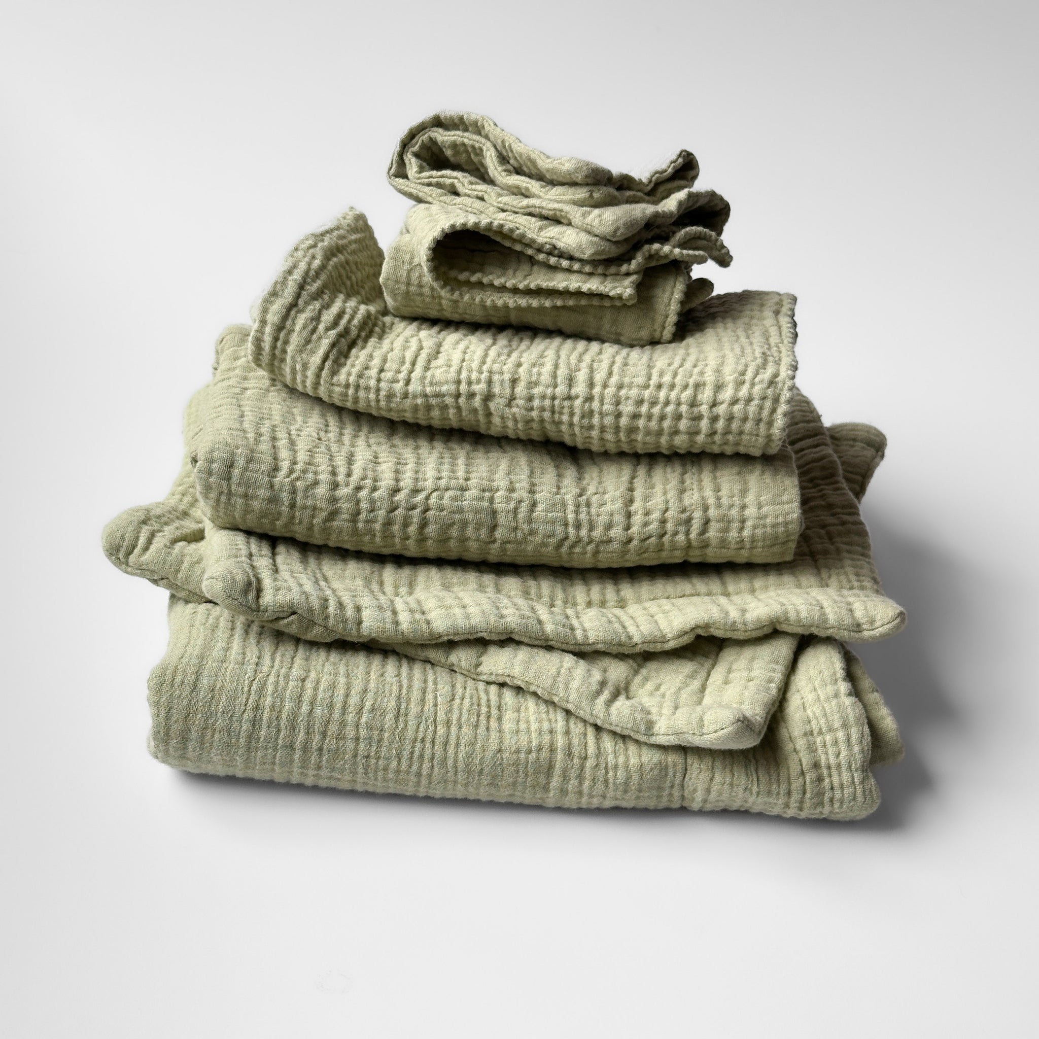 Stack of light green, celery color charley charles items. Including a dishmat, pot holders, thin towel, thick towel, and 2 washcloths. 